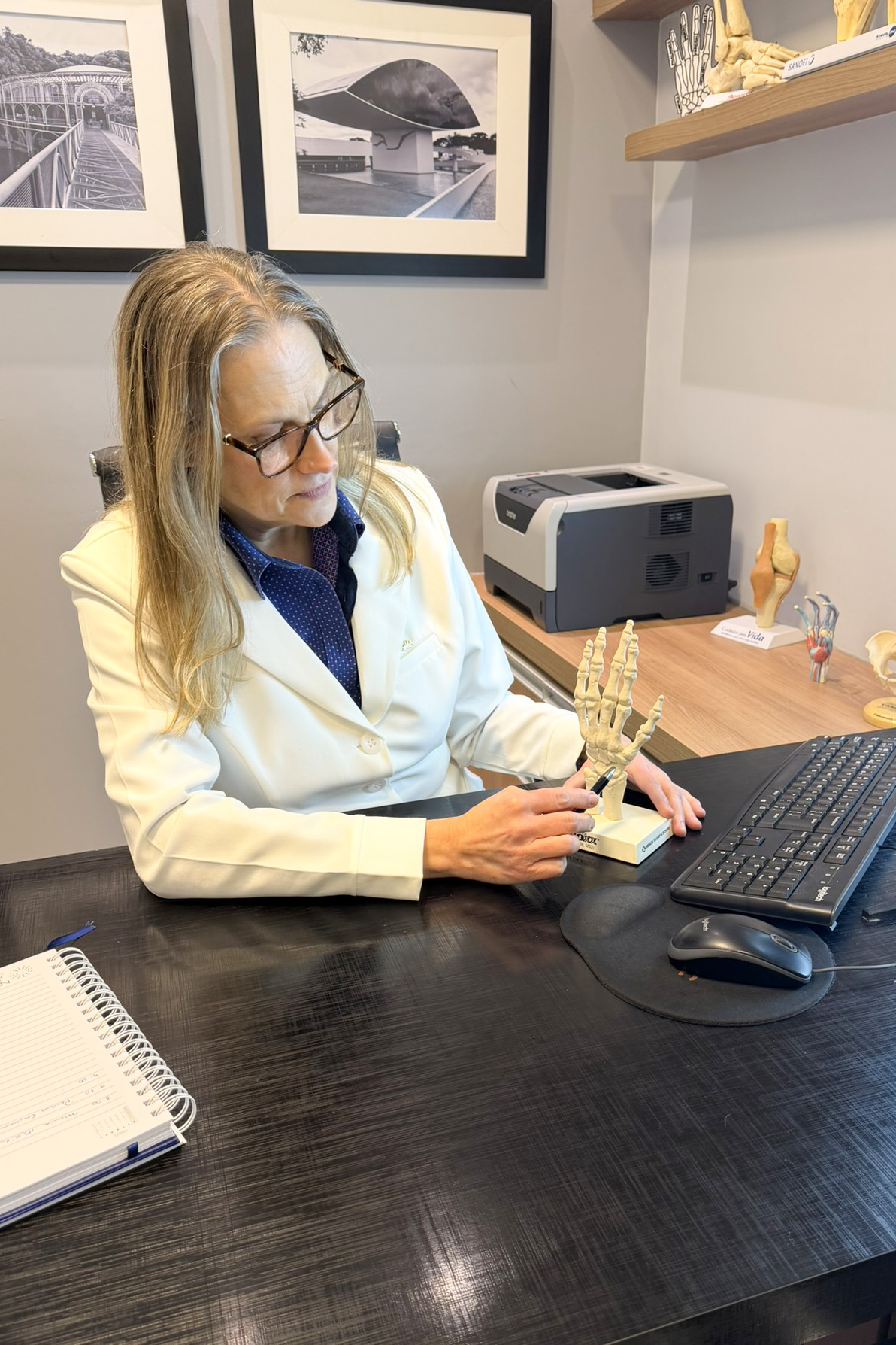 Dra. Karla Muller examinando modelo anatômico de mão
